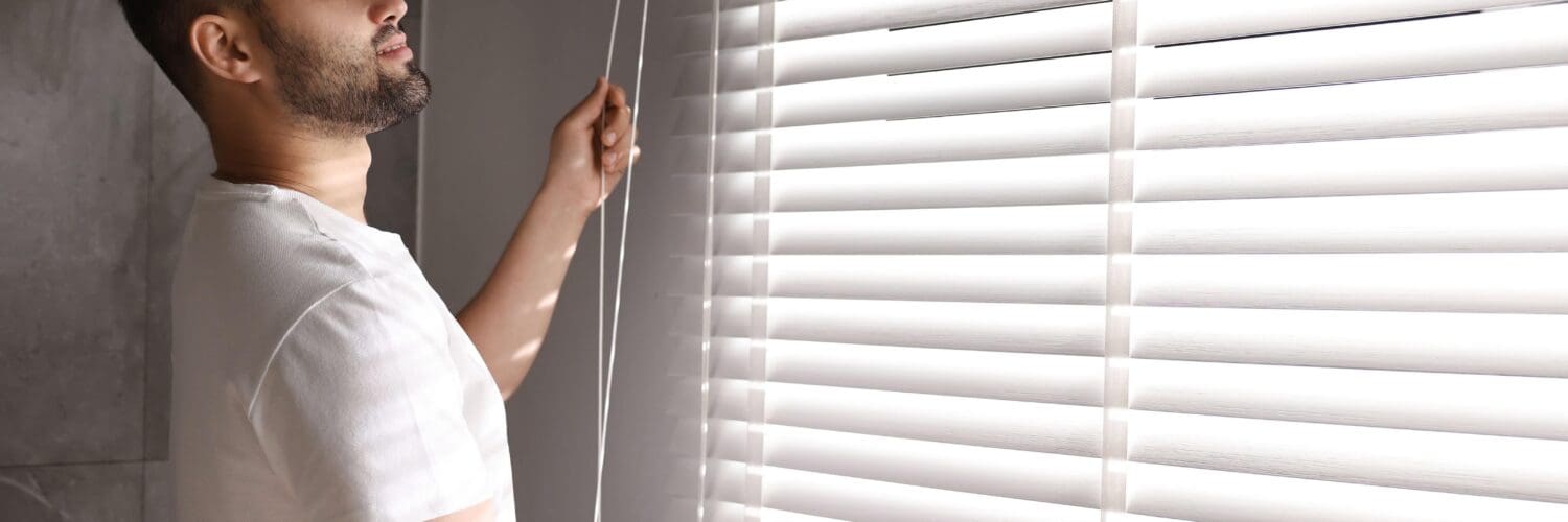 man-closing-blinds